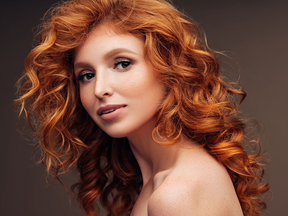 beautiful young woman with hair that showcases the fiery auburn hair color trend